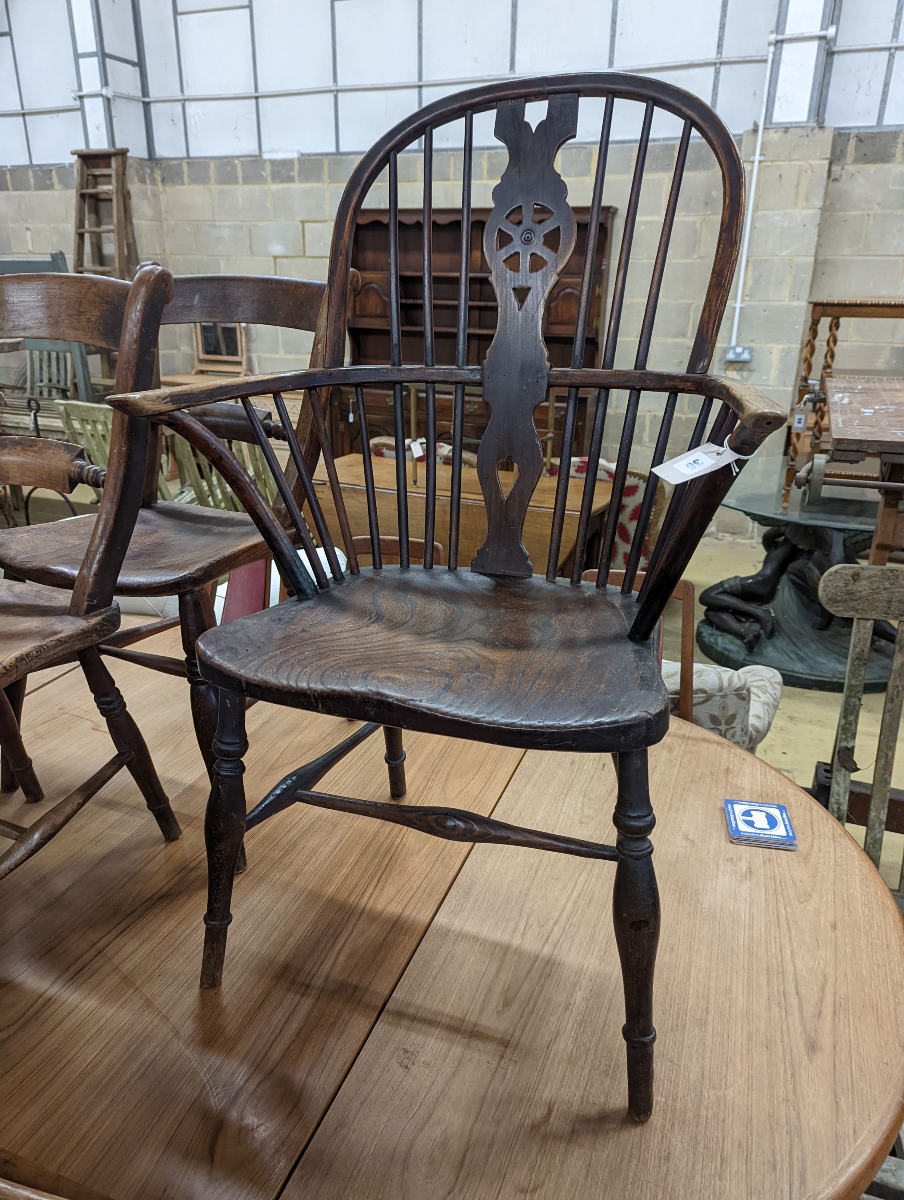 A mid 19th century Windsor ash and elm comb and wheelback armchair. H-104cm.